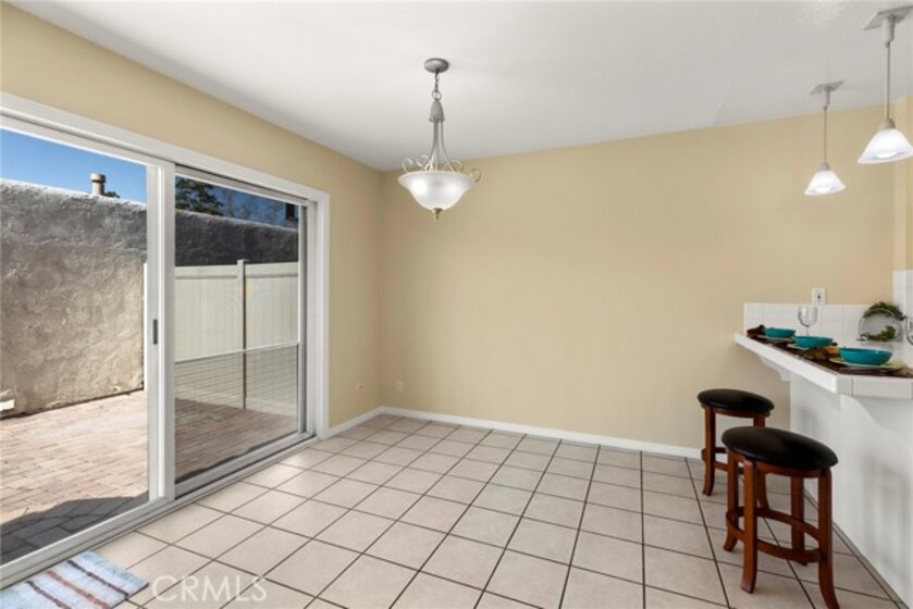LARGE VINYL PATIO DOOR BRINGS IN THE LIGHT AND SPOTLIGHTS THE TILE FLOORING THROUGHOUT.
