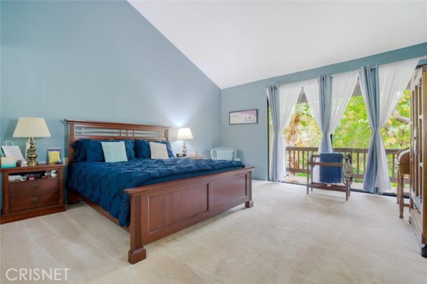 Large master bedroom with vaulted ceilings, walk-in closet and private patio