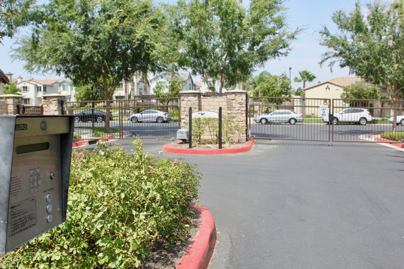 A road where cars are passing in front of gate in corona