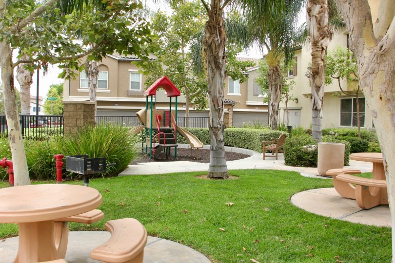 table, arm chair, pumpset and playing park is placed in front of house childrens can play