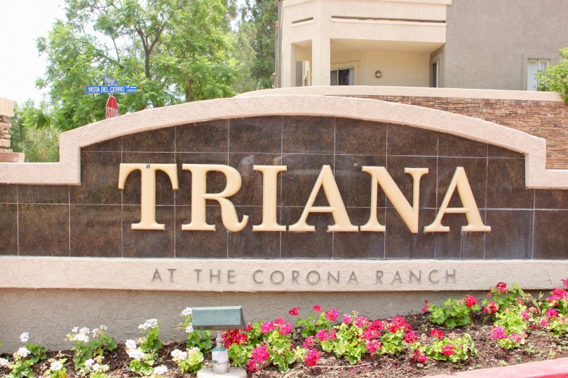 Triana at Corona Ranch sign with flowers and trees