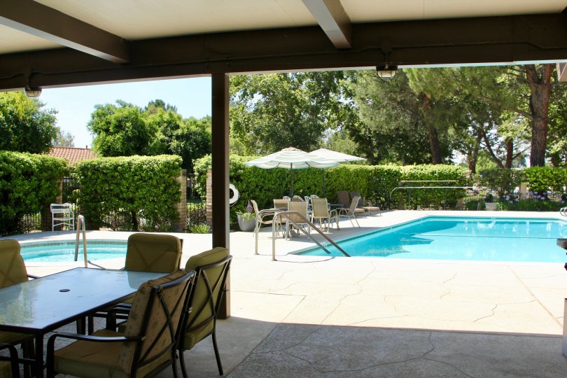 A shaded area under a canopy sits near a pool at the Seven Hills community.