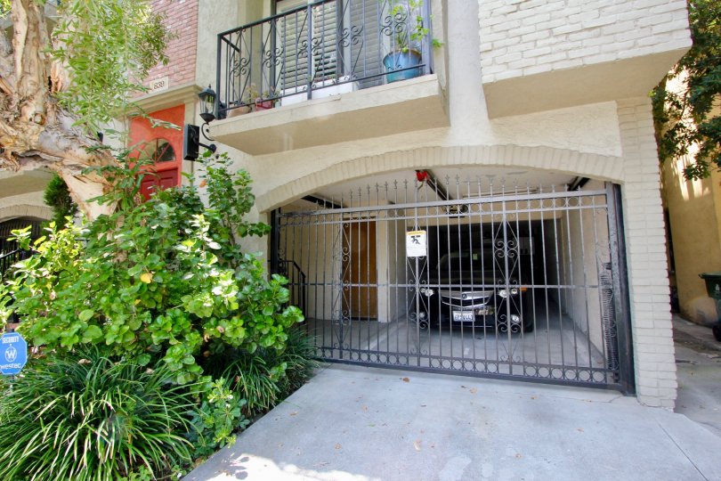 Car parked behind locked gate in a garage attached to a dwelling in Beverly Center, California.