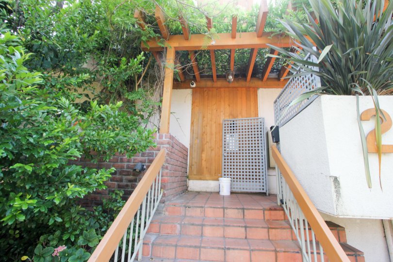 Steps surrounded by green plants and covered by a trellis in the Tower Park community of Beverly Hills, California