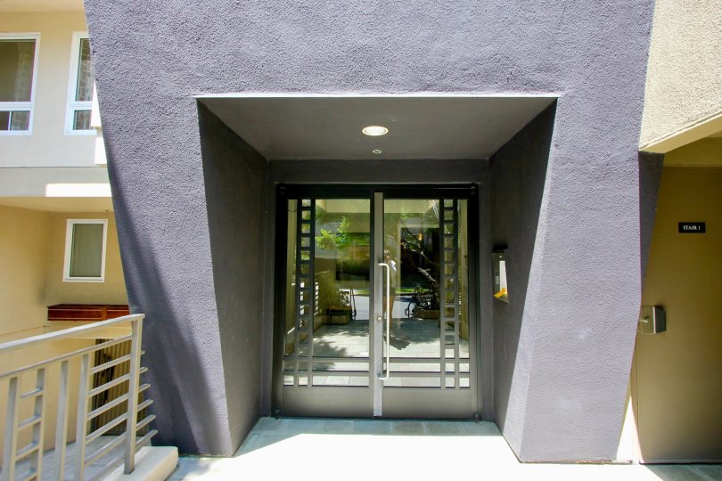 Large glass security doors and modern arch way leading into Wellesley Manor condos in Brentwood.