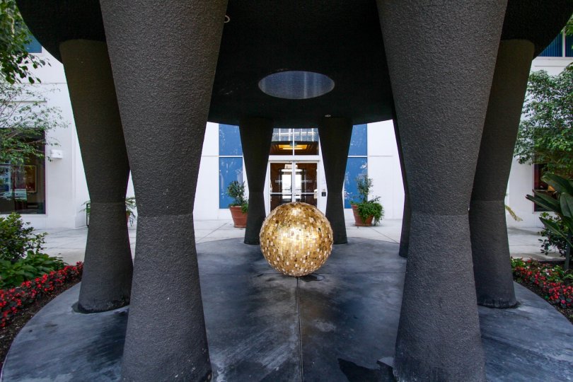 A black sculptures with a gold ball at its center greet residents at the entrance to Harbor Place Tower
