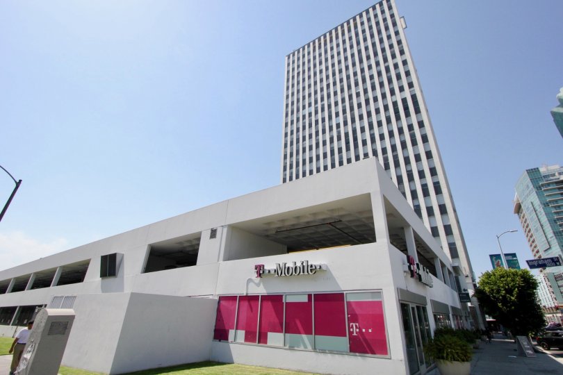 A corner location of a T-Mobile store with a high rise building in the background