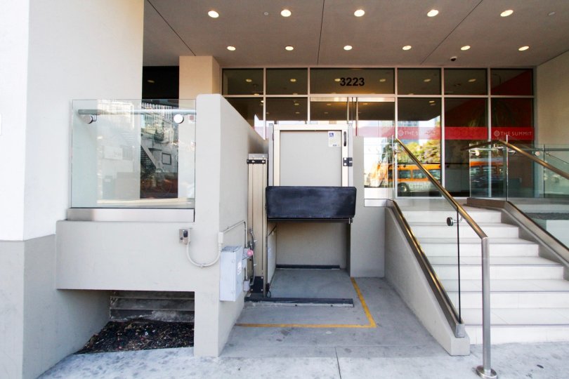A wheelchair elevator is next to the stairs at The Summit on Sixth