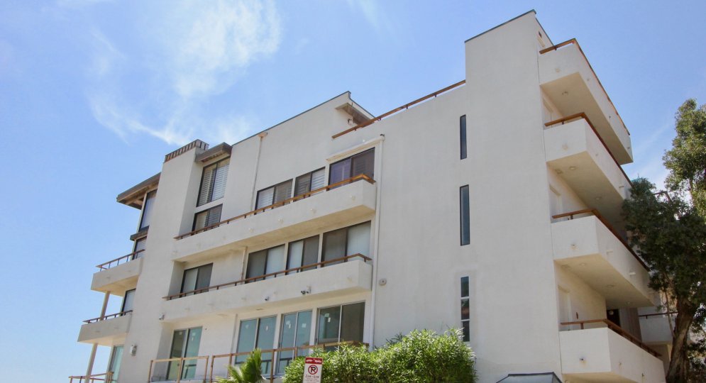 Street-level view of apartment building at 1 Eastwind in Marina del Ray, CA, showing balconies