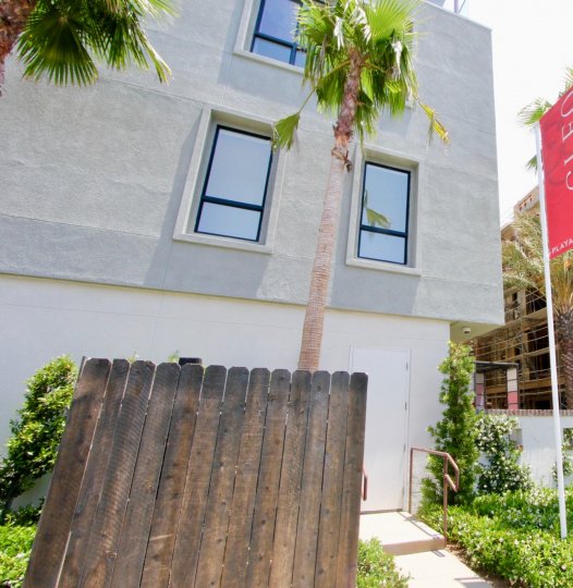 A sunny afternoon with worn wood fence and construction at Cleo in Playa Vista.