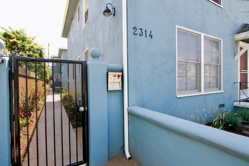 A side gate to the 2314 28th St. community with blue walls.