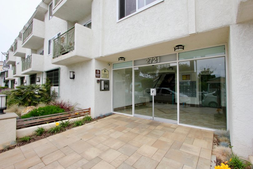 A white building in the 2721 2nd St community with a large glass front door and multiple balconies