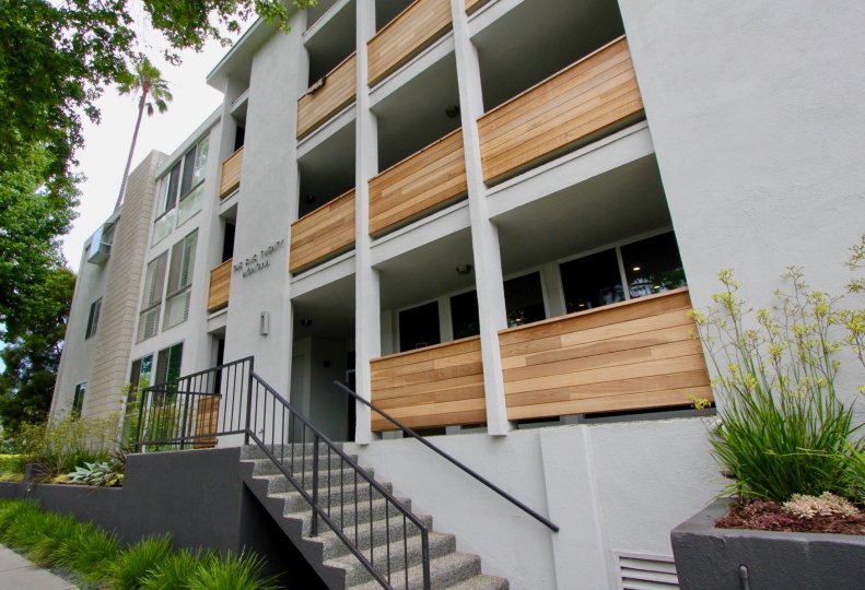 A white building in the Santa Monica Terrace community with wooden balconies