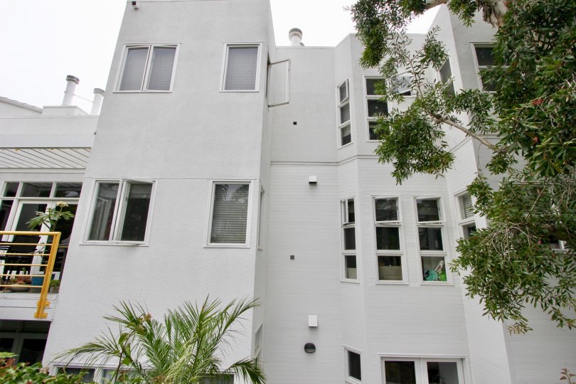 A white building in the Sea View Collection III community with a balcony and trees