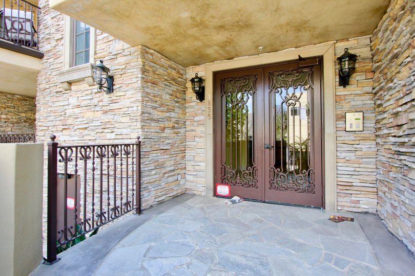 Stone entrance with decorative lamps to Borgata Residence in Westwood, CA.