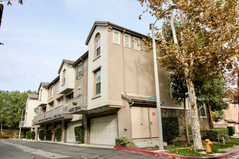 An adobe style apartment complex in the sunny city of Aliso Viejo, California which sits on Plumera. THe apartments appear to all have garages underneath the building.