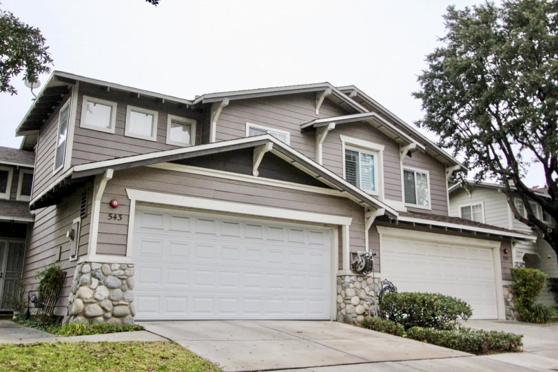 Gray town homes with stonework and garages in front