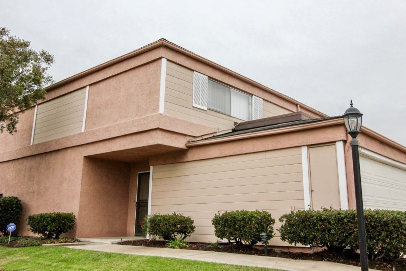 A two-storey residence in the Northwoods Village community with orangish paint and flat roofs.