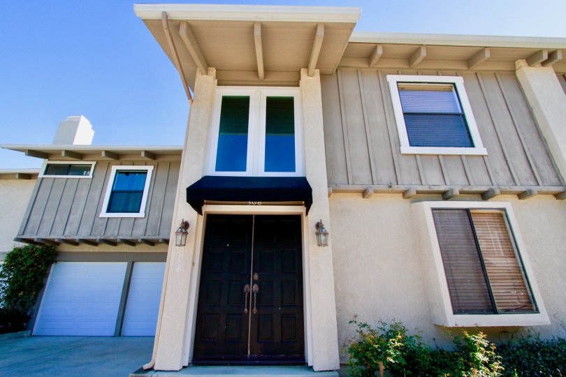 Peppertree Heights two story apartments with garages brown doors on a sunny day.