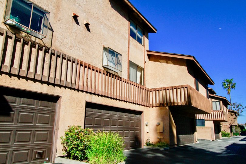 Three large brown garage doors attached to the base of town homes in Villa Maple in Costa Mesa CA