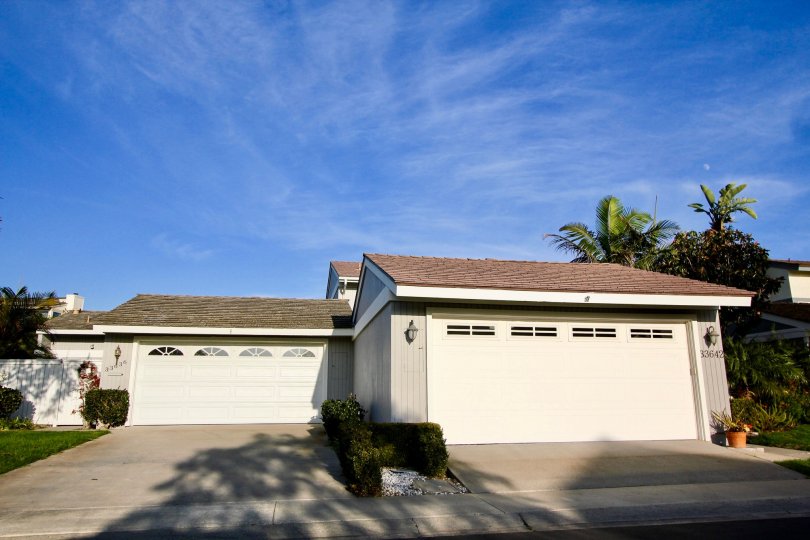 a plesant day in the niguel shores with building that has white door and back of trees