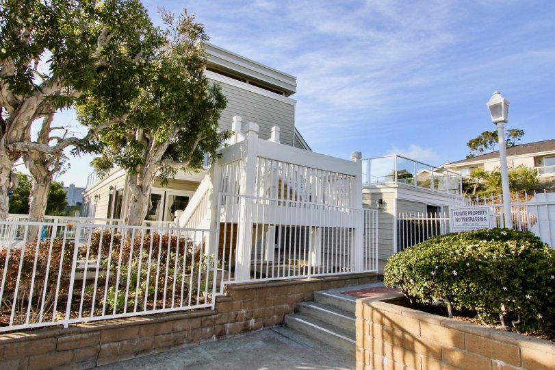 a sunny day in the sea ridge with a building that has white coloured gate that has board which says no trespassing