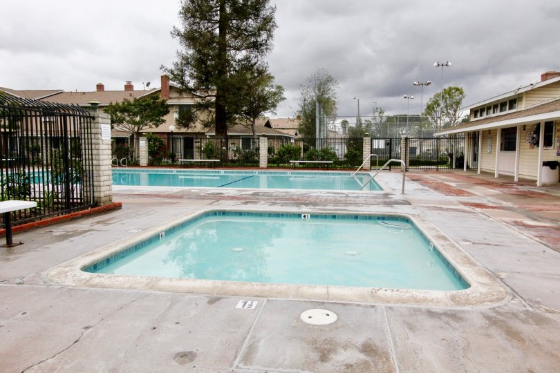 A long rectangle pool sits next to a square hot tub at Harbor Valley in Fountain Valley CA