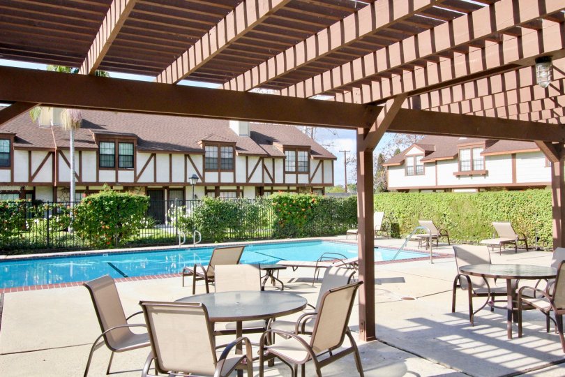 Relaxing pool near residential homes with tables and shading in Chelsea Park Estates community.