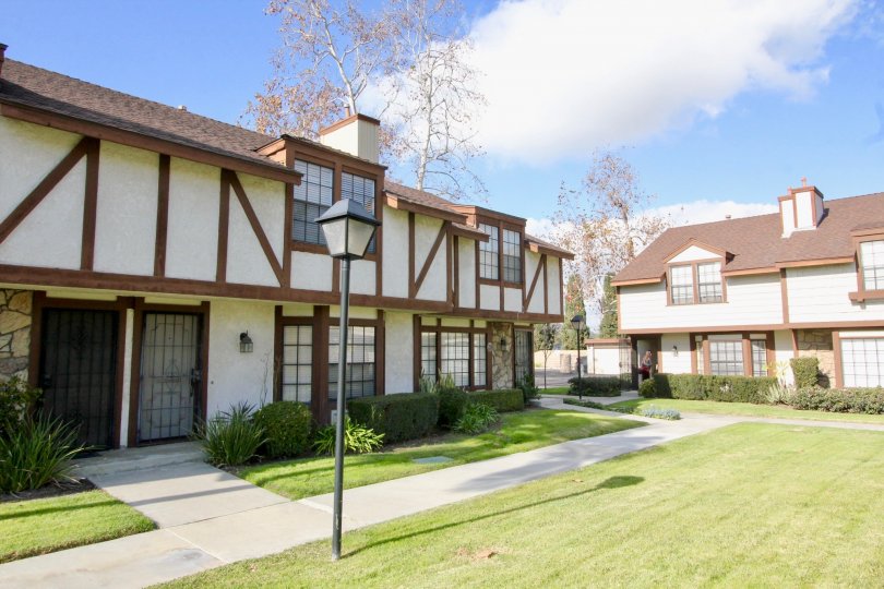 The town homes that are white with a tudor wood work a light pole out front in chelsea park estates community in fullerton, california.