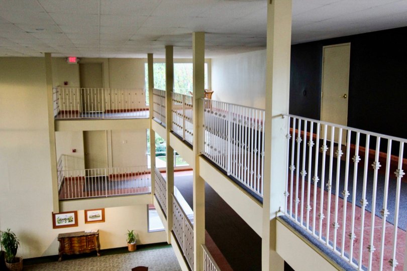 Indoor view with 2 balconies with white rails without many ceiling lights in Club Acacia community.