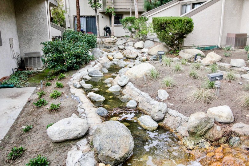 water is running between the rocks and stones that are outside the villa in Hidden Lakes