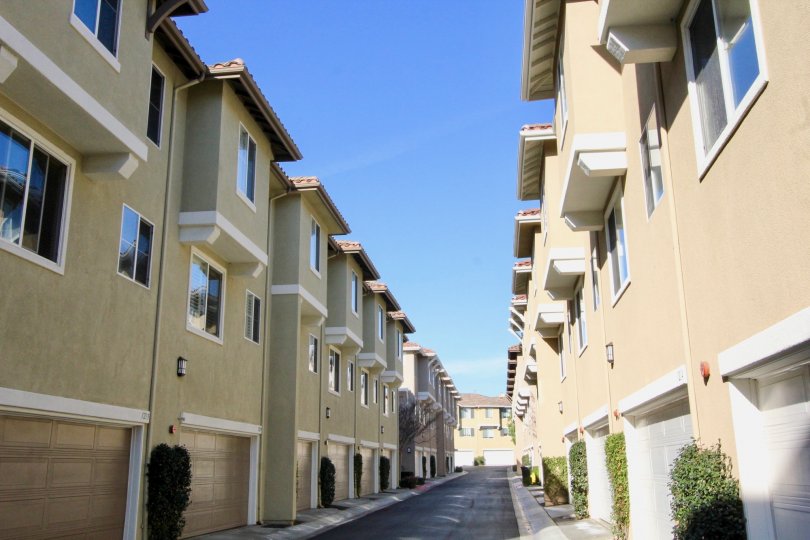 A street in the Plaza Walk community between apartment buildings on a sunny day.