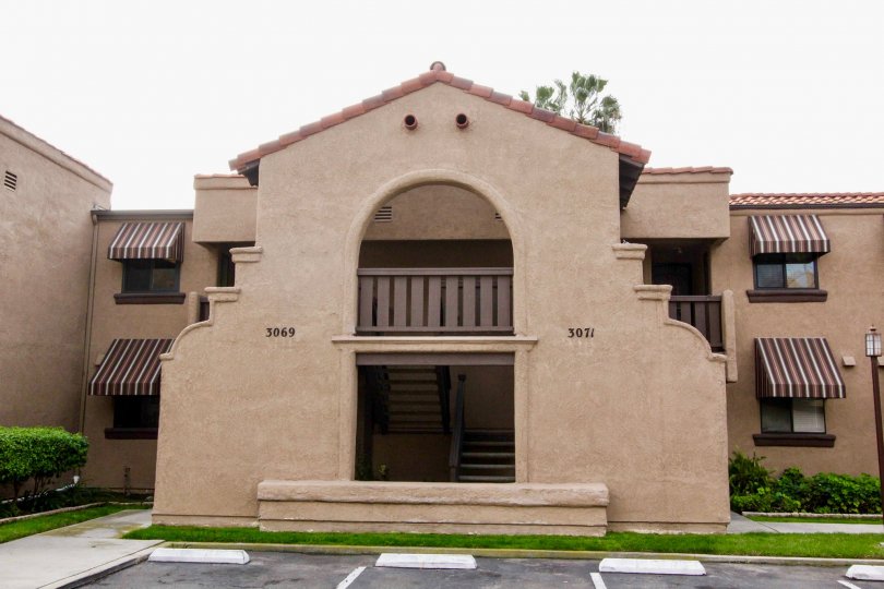 A large condo building with a large arch at it's center in Via Valencia, Fullerton CA