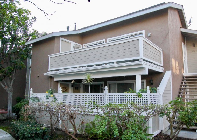 THE BUILDING IN THE BROOKHAVEN CIRCLE WITH THE UPSTAIRS, PLANTS, TREES, DISH ANTENNA