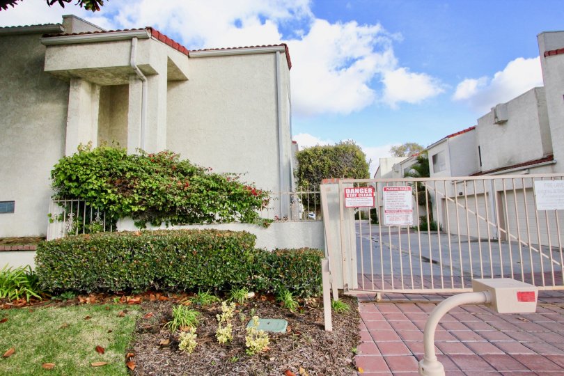 THIS IS THE ENTRANCE WAY TO THE APARTMENTS THAT SHOWS DANGER BOADR ON THE GATE, NEARBY PLANTS ARE PLANTED WHICH IS IN THE CITY OF GARDEN GROVE