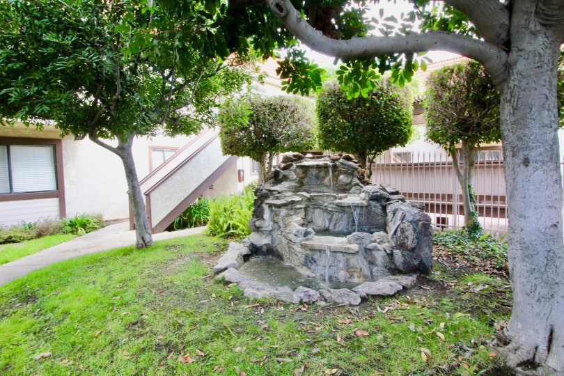 A stone structure in a garden area of a house with exterior staircase