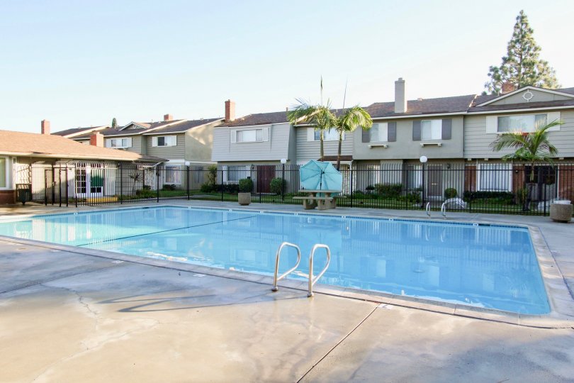 THE FLAT IN THE GARDEN VALLEY WITH THE UMBRELLA, SWIMMING POOL, STONE BENCHES, PLANTS, TREES