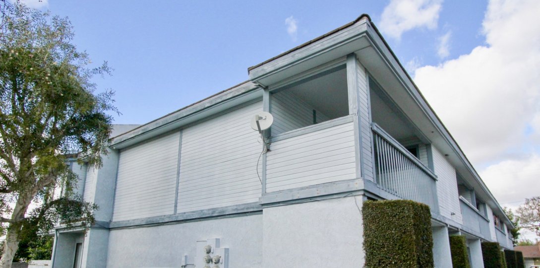 A two story apartment with a front balcony at Hewitt Place Townhomes, in Garden Grove California.