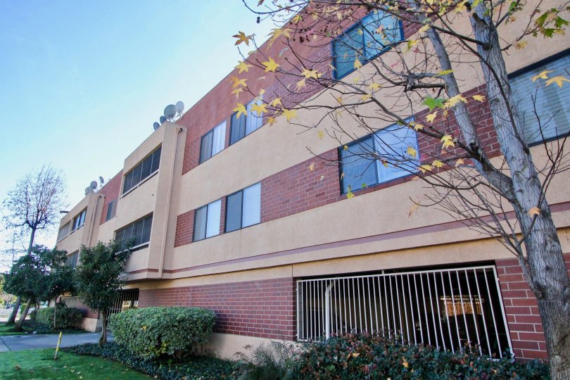 Sunny red brick building in Garden Grove, CA with green trees and bushes