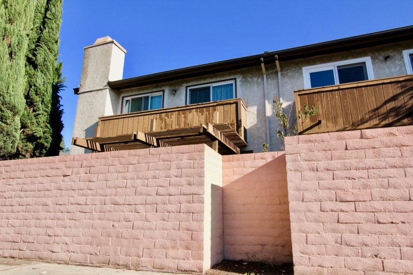 Double storeyed house with an wooden balcony and high brick wall surrounding