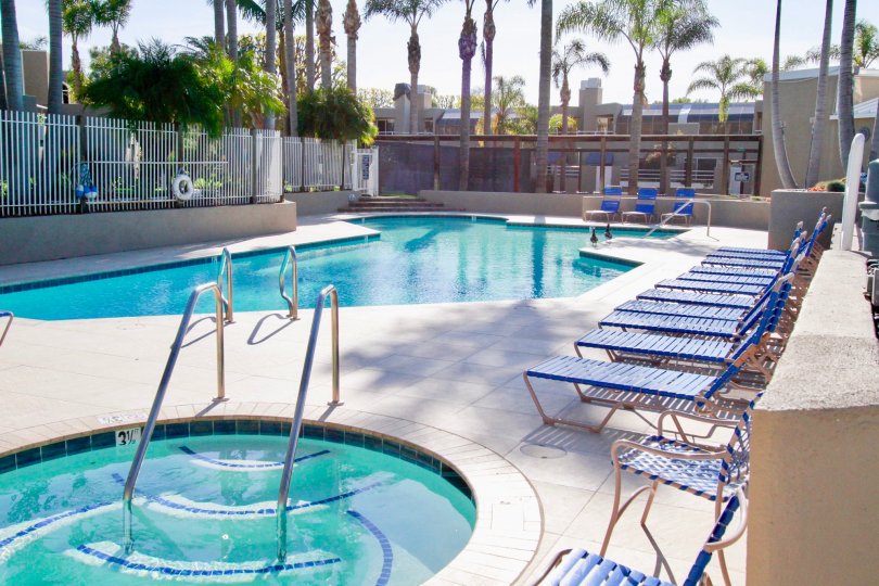 Seabridge pool and hot tub with deck chairs and palm trees.