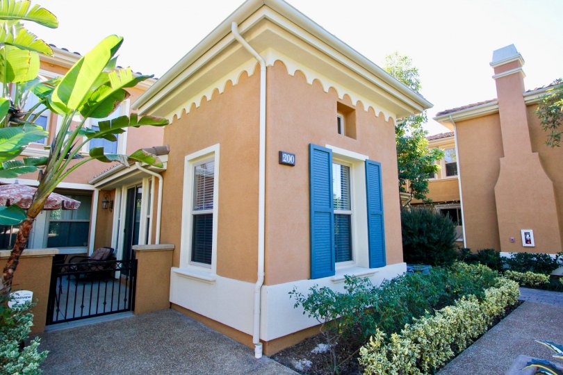 A Babylonian style home with decorative blue shutters inside Garland Park in Irvine CA
