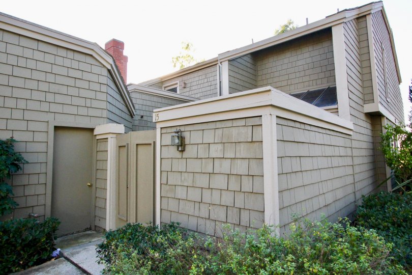 A gray condo covered in wooden shingles inside the Glen Garden Homes in Irvine CA