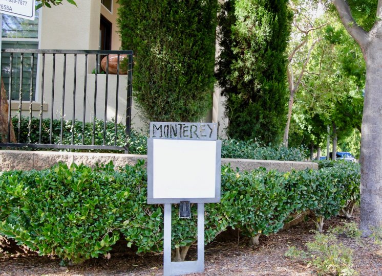 A blank signboard alongside a low fence in the Monterey community.