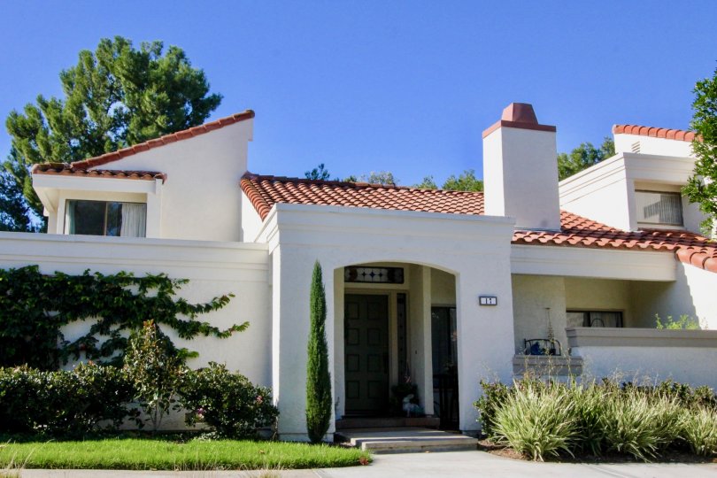 Entrance to white home with tile roof, and plantings in Villas at RSJ, Irvine, CA