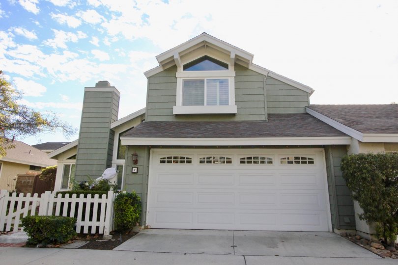 A sunny day in the area of Windwood Garden Homes, outside, garage, condo, tree, chimney, fence