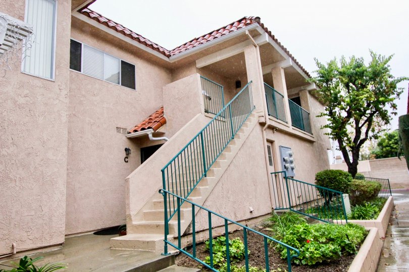 a pleasant day in the fashion knolls with a house that has roofless top and steps in center and garden in front