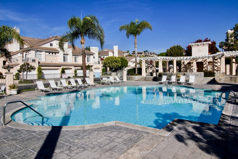 Clear blue swimming pool in stone courtyard surrounded by villas in Breakers.