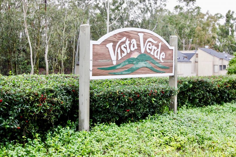 A partly cloudy day by a Vista Verde sign in the Vista Verde Townhomes area with lots of trees and greenery around