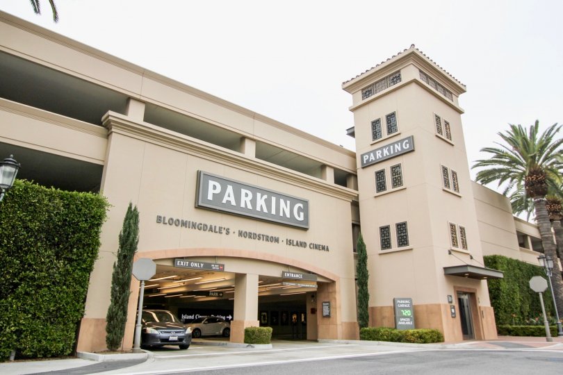 THE BUILDING IN THE Meridian WITH THE CAR PARKING, PARKING BOARD, PLANTS, TREES
